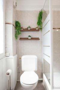 baño con aseo y plantas en la pared en Château de Versailles à 7 minutes plus parking gratuit à 4 minutes, en Le Chesnay