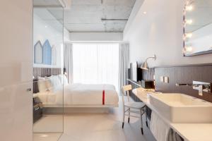 a hotel room with a bed and a sink at Ruby Zoe Hotel London in London