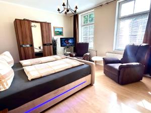 ein Schlafzimmer mit einem Bett und einem Stuhl in der Unterkunft Haus Burmeister in Sassnitz