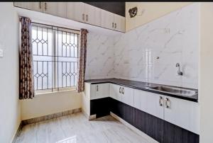 an empty kitchen with a sink and a window at Hazel Inn Manyata in Bengaluru