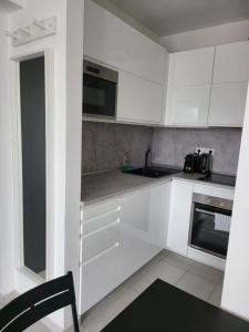 a white kitchen with a sink and a stove at SDP Meder B401 Apartment in Budapest