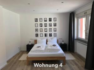 a white bedroom with a bed with two pillows at Zentrale Innenstadt-Wohnung in Würzburg