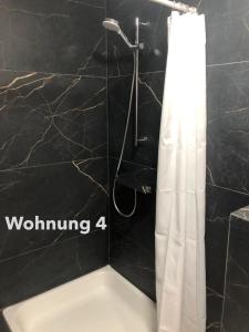 a shower with a white shower curtain in a bathroom at Zentrale Innenstadt-Wohnung in Würzburg