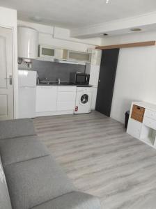 uma sala de estar com um sofá e uma cozinha em Superbe appartement en plein centre ville em Viarmes