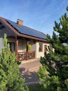 a house with a solar roof and some trees at Zielone Miejsce in Karwia