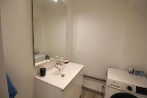 a white bathroom with a sink and a mirror at L'etoile : Beau T3 rénové /Wifi in Angoulême