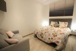 un dormitorio con una cama y un sofá en L'etoile : Beau T3 rénové /Wifi, en Angulema