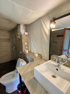 uma casa de banho com um lavatório e um WC em The Cliff Resort Pokhara Kushma em Kusma