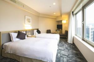 Postel nebo postele na pokoji v ubytování Hotel JAL City Nagano