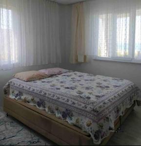 ein Bett mit einer Decke in einem Schlafzimmer in der Unterkunft Denize Karşı Huzur Dolu Komple Kır Evi 