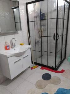 ein Bad mit einer Dusche, einem Waschbecken und einem Spiegel in der Unterkunft Denize Karşı Huzur Dolu Komple Kır Evi 