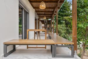 a table and chairs on the porch of a house at TWINS Sea Front Villas in Nea Kalikratia