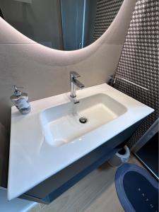 La salle de bains est pourvue d'un lavabo blanc et d'un miroir. dans l'établissement Il Tufo In Festa, à Matera