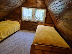 sypialnia z 2 łóżkami w drewnianym domku w obiekcie Domek nad rzeką w Łącku