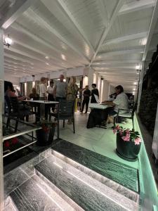 een groep mensen die aan tafel zitten in een restaurant bij Hotel Ergi in Durrës