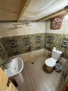 a bathroom with a white toilet and a sink at Raha Camp in Wāsiţ