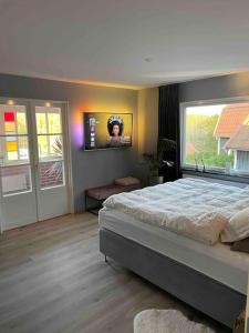 um quarto com uma cama e uma televisão na parede em Villa Valjensa em Sölvesborg