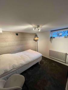 a bedroom with a bed and a chair and a window at Villa Valjensa in Sölvesborg