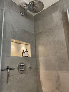 a bathroom with a shower with a sink and a mirror at Villa Valjensa in Sölvesborg