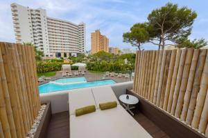 un balcon avec un banc et une piscine dans l'établissement HM Balanguera Beach - Adults Only, à Playa de Palma