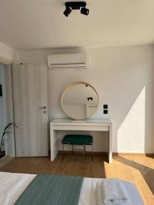 a bedroom with a mirror and a desk with a chair at Elounda Port Apartment in Elounda
