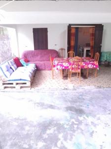sala de estar con sofá púrpura y mesa en Maison La voûte plage à 50m et rivière à proximité, en Vieux-Habitants