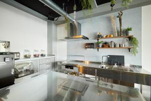 a large kitchen with a stainless steel counter top at Drop Inn Tottori in Tottori
