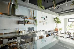 a large kitchen with stainless steel counters and a sink at Drop Inn Tottori in Tottori