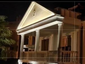 a reflection of the front of a house at night at JOANDI Apartments Gevgelija in Gevgelija