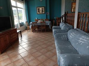a living room with a couch and a tv and a table at La Cariñosa in Naveces