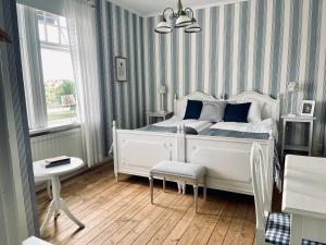 1 dormitorio con 1 cama blanca y 1 silla en Göta Hotell en Borensberg