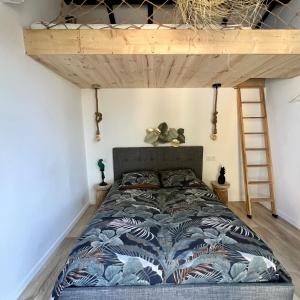 uma cama num quarto com uma cama alta em Mini Villa St-Lucie Porto-Vecchio vue mer 5mnplage em Zonza