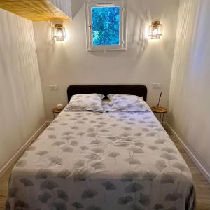uma cama num pequeno quarto com uma janela em Mini Villa St-Lucie Porto-Vecchio vue mer 5mnplage em Zonza