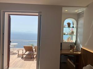 una puerta que da a un balcón con vistas al océano en SeaJewelsDeluxurySuite, en Amalfi