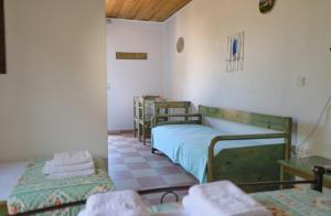 a room with two bunk beds and two tables at Koralia Apartments in Kythira