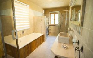 baño grande con bañera y lavamanos en Chalet Altaussee, en Altaussee