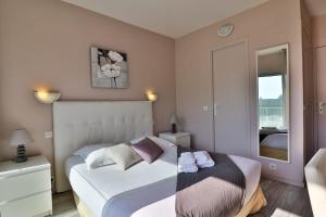 a bedroom with two beds and a mirror at Hotel Le Golfe Bleu in Cavalaire-sur-Mer