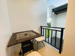 Couple Pad with own bath near Clark (Casa Isabela) في Mabalacat: شرفة مع طاولة زجاجية وكراسي على شرفة