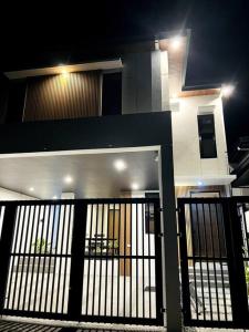 a house with a black gate in front of it at Couple Pad with own bath near Clark (Casa Isabela) in Mabalacat