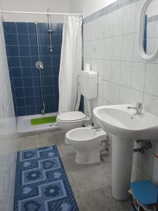 a bathroom with a toilet and a sink and a shower at Casa Martine in Orosei