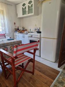 a kitchen with a white refrigerator and a red bench at Apartmani kod Kmeta in Janja