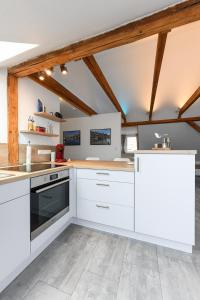 a kitchen with white appliances and wooden ceilings at Ferienwohnung im Haus Windrose in Wittmund