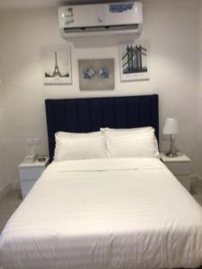 Schlafzimmer mit einem großen weißen Bett mit einem schwarzen Kopfteil in der Unterkunft سمو 4 in Riad