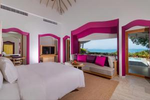 a bedroom with a white bed and a couch at Phulay Bay, A Ritz-Carlton Reserve in Tab Kaek Beach
