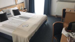 una habitación de hotel con una cama grande con un cartel. en Miratel, en Mitterteich