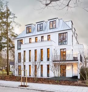 ein weißes Haus mit vielen Fenstern in der Unterkunft Villa Baltique in Ostseebad Sellin