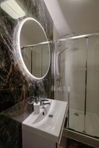 カジミエシュ・ドルニにあるWilla Irys z basenemのバスルーム(シンク、鏡、シャワー付)