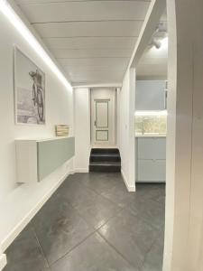 a hallway with white walls and a staircase with a green door at Loft Torlonia in Rome