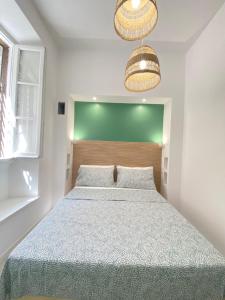 a bedroom with a bed with a green headboard at Loft Torlonia in Rome