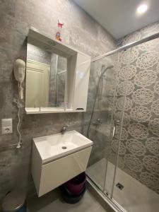 a bathroom with a sink and a shower and a mirror at 1st line apartment in Kobuleti in K'obulet'i